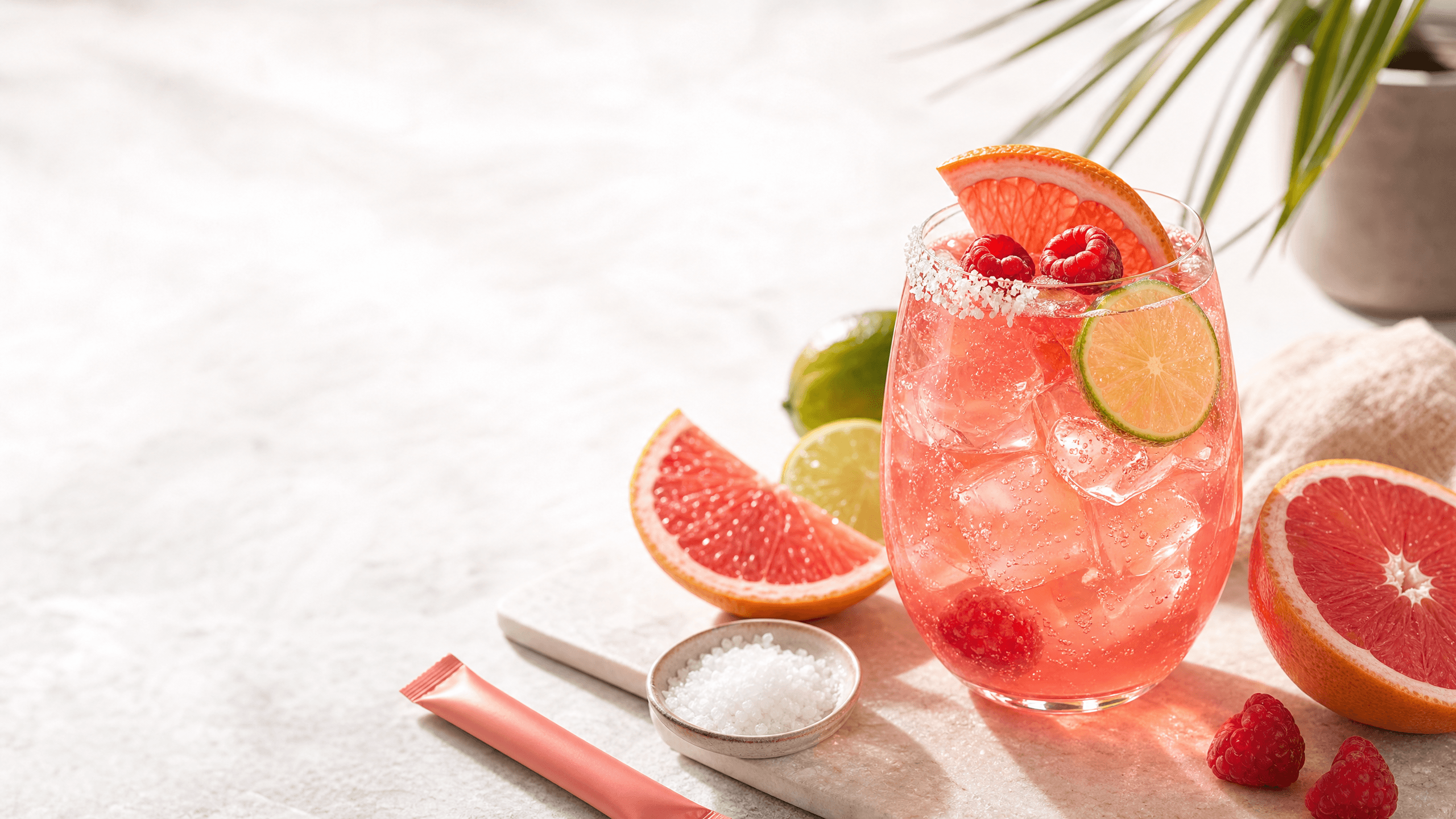A raspberry kava Paloma spritz with grapefruit, lime, raspberries, sparkling bubbles, and a salt rim